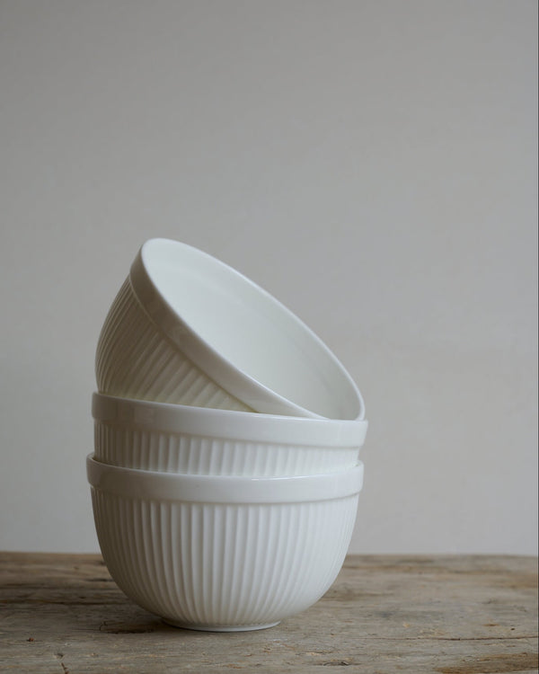 Stack of white striated tea bowls in bone china