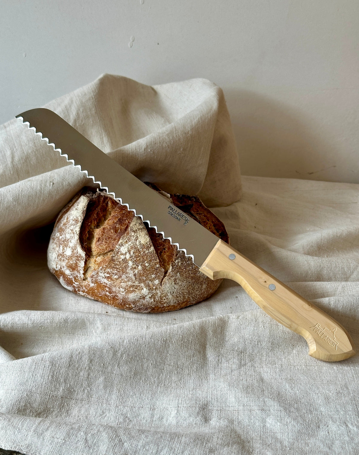 Sourdough bread with a bread knife on a white cloth
