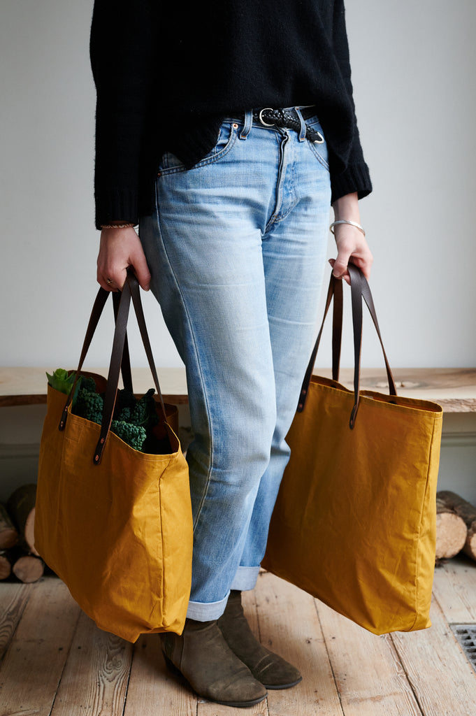 Two waxed cotton bags in cumin yellow, with leather straps