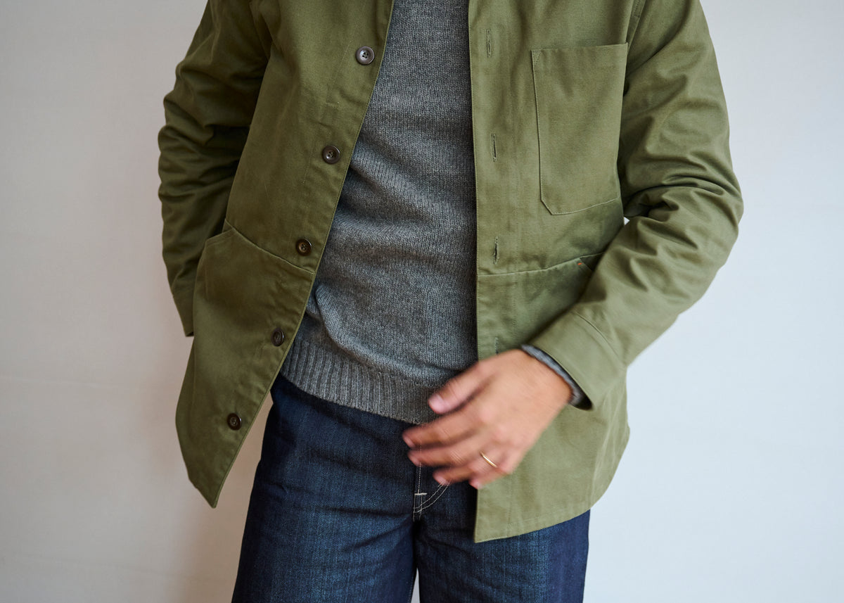 Close up detail of a men's cotton canvas jacket in Lovat green with metal buttons