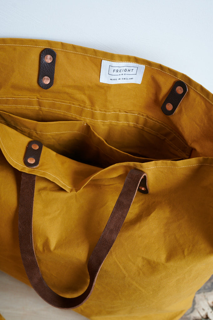 Cumin yellow bag in drywax finish with  leather straps and two internal pockets