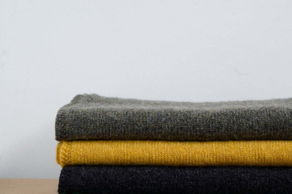 A stack of knitted scarves in different colours